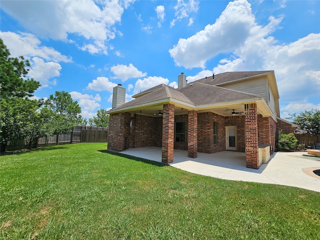 back of property featuring ceiling fan, a patio area, and a yard