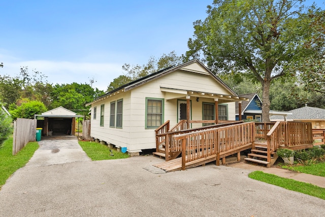 view of front facade featuring a porch, a garage, an outdoor structure, and a wooden deck