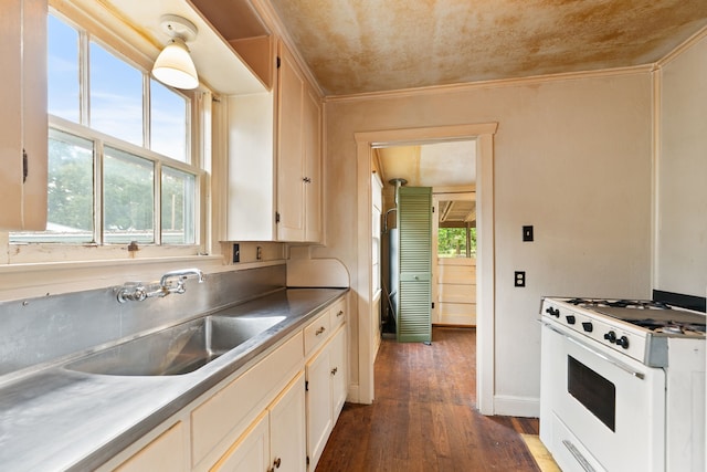 kitchen featuring white range with gas cooktop, plenty of natural light, and dark hardwood / wood-style floors