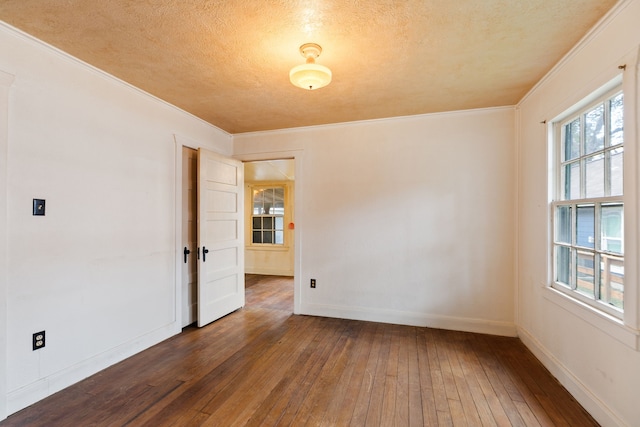 spare room with a textured ceiling, dark hardwood / wood-style flooring, and ornamental molding