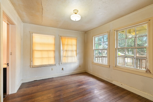 unfurnished room featuring dark wood-type flooring, a textured ceiling, and ornamental molding