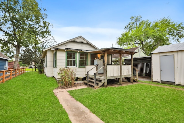 back of house with a yard and a storage shed