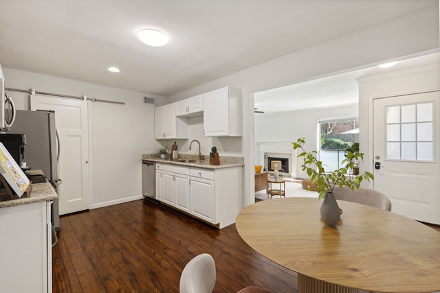 kitchen featuring a barn door, white cabinetry, sink, and dark hardwood / wood-style floors