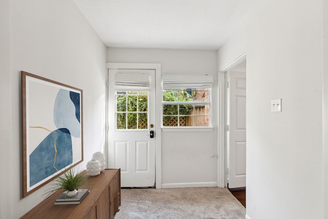 doorway to outside featuring carpet floors