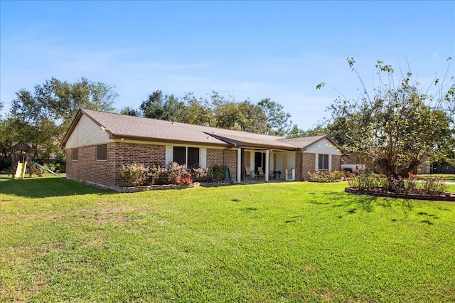 view of front of home featuring a front yard and a playground