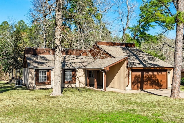 back of house featuring central air condition unit, a lawn, and a garage