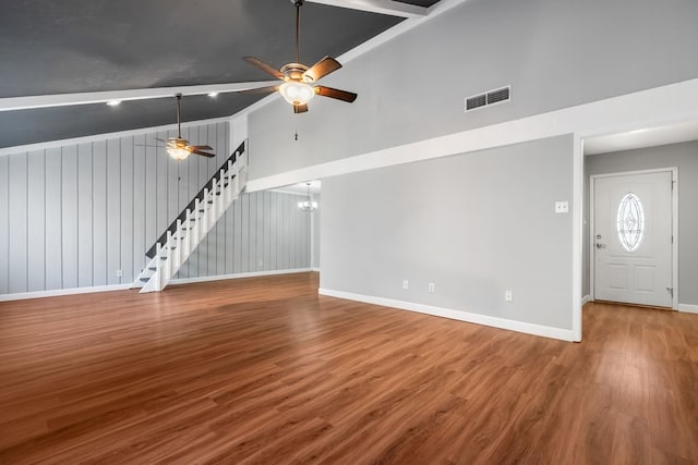 unfurnished living room featuring ceiling fan with notable chandelier, wood-type flooring, and lofted ceiling