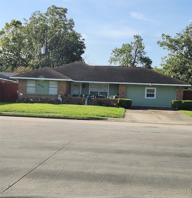 ranch-style home featuring brick siding and a front lawn