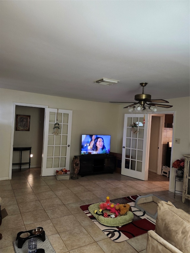 tiled living room with ceiling fan and french doors