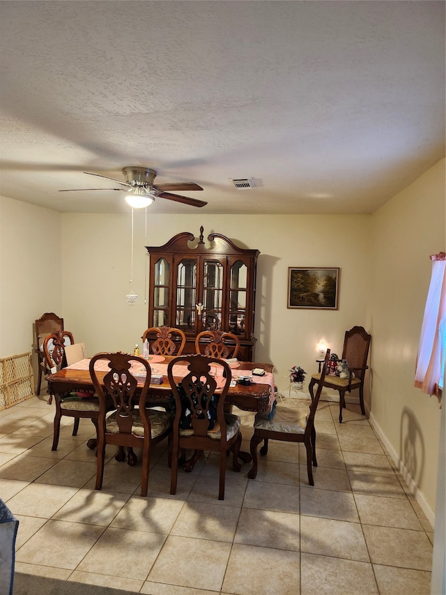 tiled dining space featuring ceiling fan