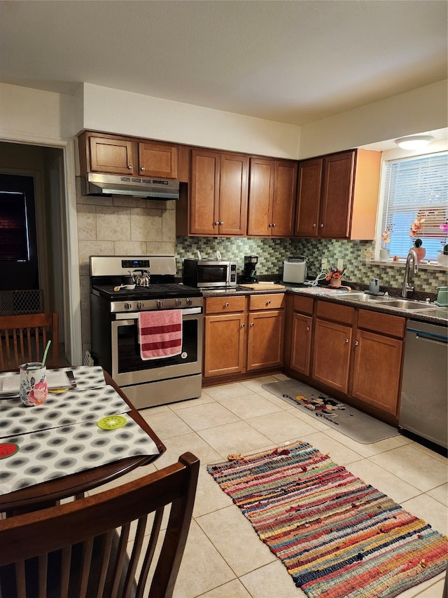 kitchen featuring tasteful backsplash, sink, light tile patterned floors, and stainless steel appliances