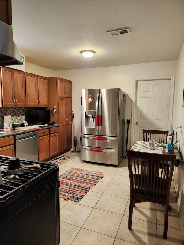 kitchen featuring ventilation hood, backsplash, stainless steel appliances, and light tile patterned floors