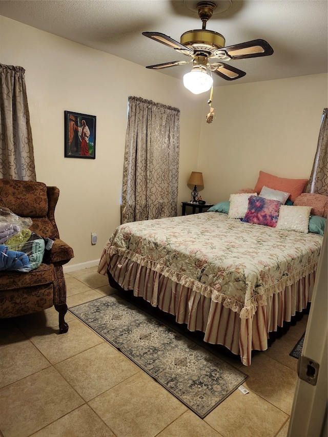 tiled bedroom featuring ceiling fan