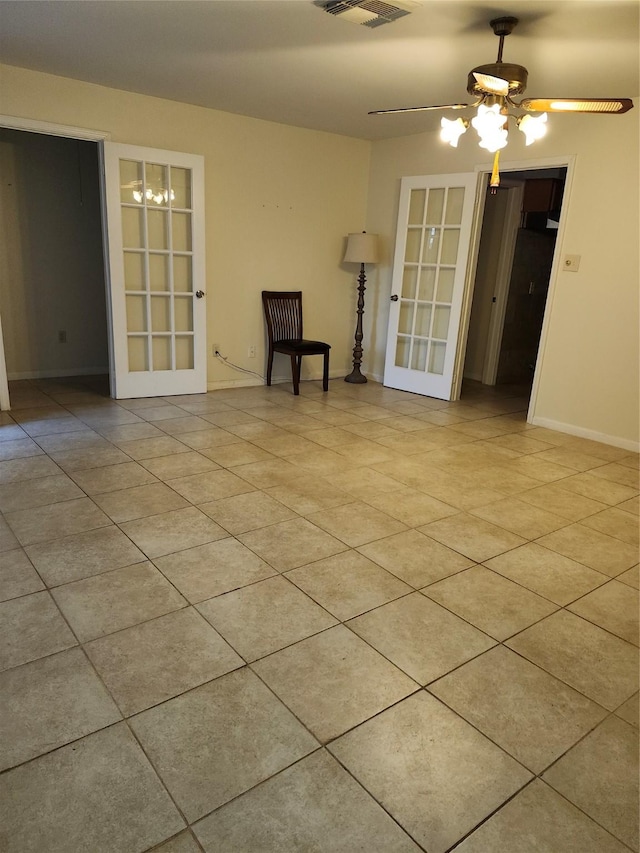 spare room with french doors, light tile patterned floors, visible vents, ceiling fan, and baseboards