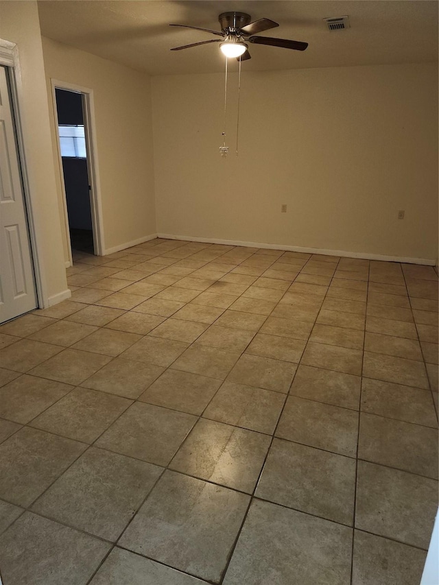 spare room featuring baseboards, light tile patterned flooring, visible vents, and a ceiling fan