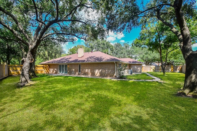 rear view of property featuring a lawn