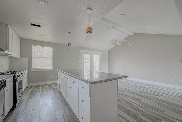 kitchen featuring white cabinetry, stainless steel gas range oven, a wealth of natural light, and light hardwood / wood-style floors