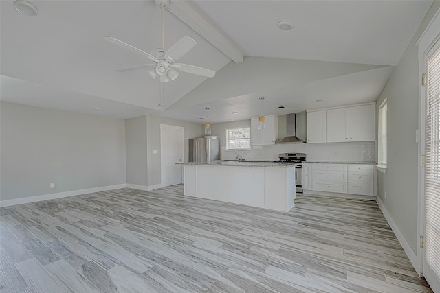 kitchen featuring wall chimney range hood, vaulted ceiling with beams, light wood-type flooring, white cabinetry, and stainless steel appliances