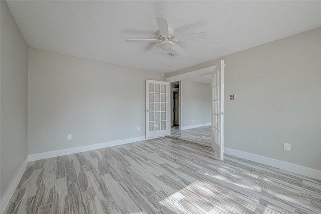 empty room featuring french doors, a textured ceiling, light hardwood / wood-style flooring, and ceiling fan