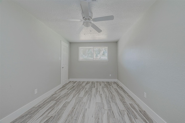 unfurnished room featuring a textured ceiling, light wood-type flooring, and ceiling fan