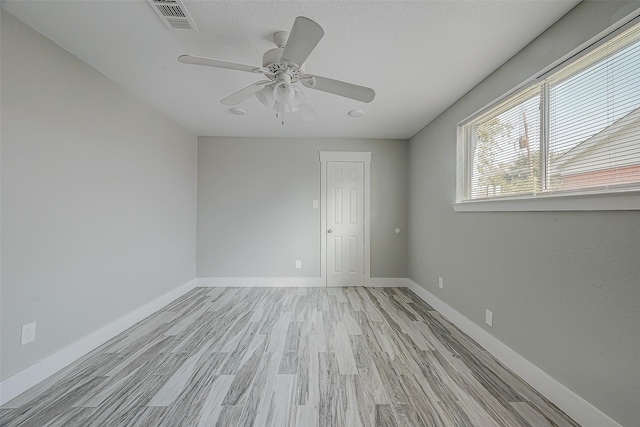 empty room with light hardwood / wood-style flooring and ceiling fan