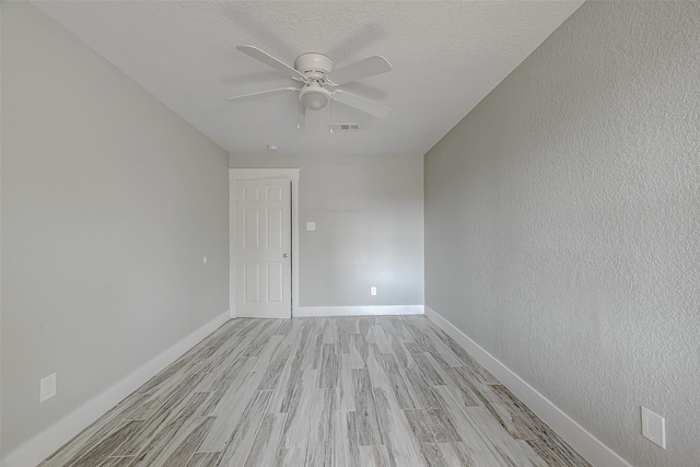 unfurnished room featuring ceiling fan, light hardwood / wood-style floors, and a textured ceiling