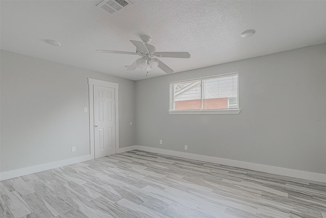 empty room with ceiling fan, a textured ceiling, and light hardwood / wood-style flooring