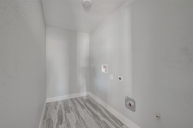 washroom featuring a textured ceiling, washer hookup, light wood-type flooring, and hookup for an electric dryer