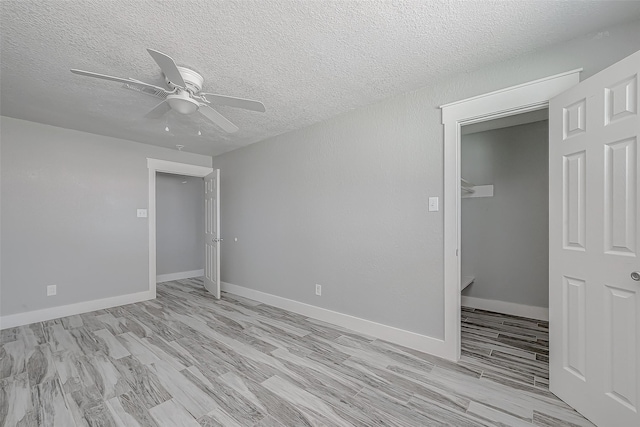 unfurnished bedroom with a textured ceiling, light wood-type flooring, a closet, and ceiling fan