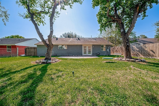 rear view of property with a yard, french doors, and a patio