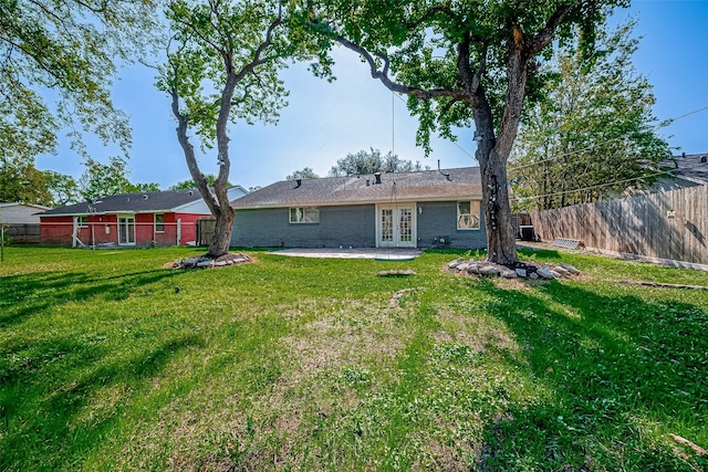 back of house featuring a lawn, french doors, and a patio