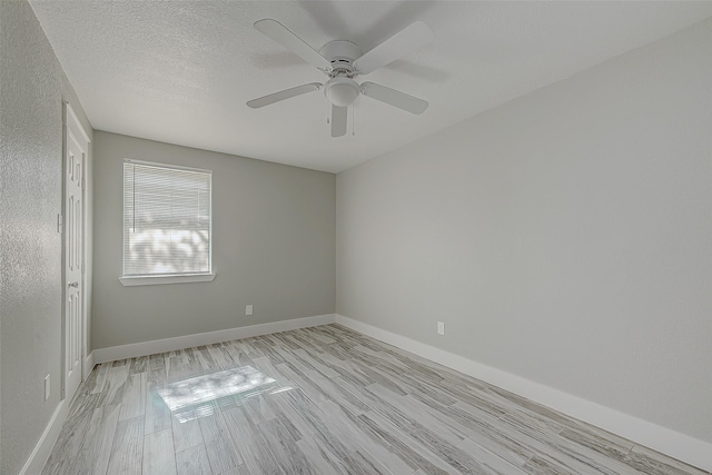 empty room with ceiling fan, a textured ceiling, and light wood-type flooring