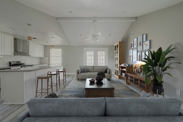 living room with a textured ceiling, dark hardwood / wood-style flooring, lofted ceiling with beams, and ceiling fan