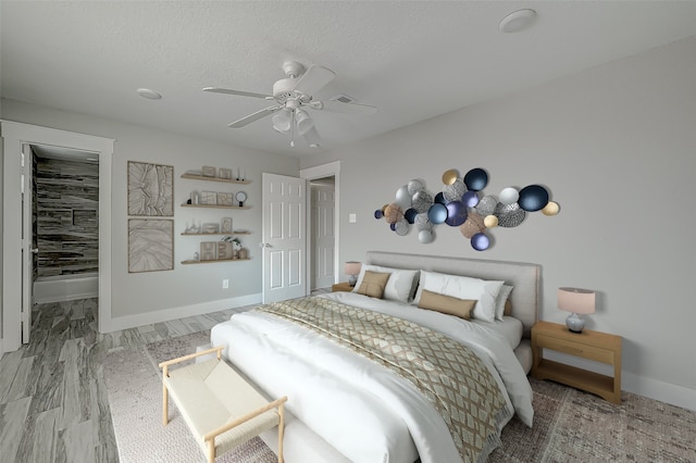 bedroom featuring ceiling fan, a spacious closet, a textured ceiling, wood-type flooring, and a closet