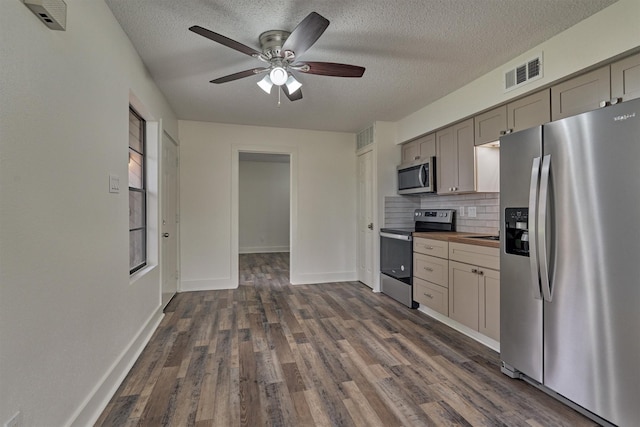 12900 Walden Rd Unit 105A, Montgomery, TX 77356 - kitchen featuring appliances with stainless steel finishes, a ceiling fan, gray cabinetry, dark wood-style floors, and a textured ceiling