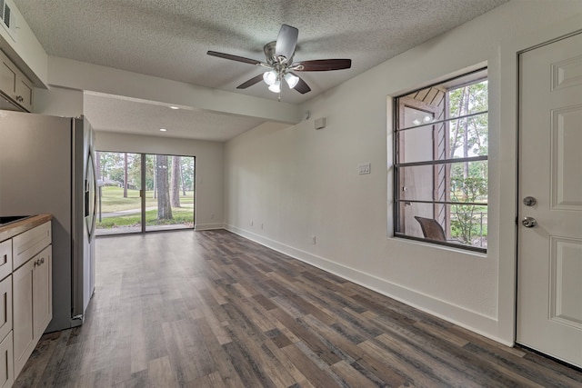 interior space with ceiling fan, dark hardwood / wood-style flooring, and a textured ceiling