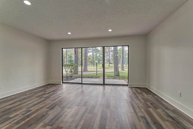 spare room with plenty of natural light, dark hardwood / wood-style flooring, and a textured ceiling