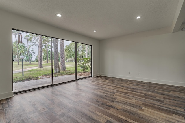 empty room featuring dark hardwood / wood-style floors and a textured ceiling