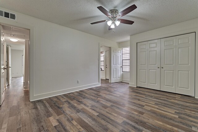 unfurnished bedroom with a closet, ceiling fan, dark hardwood / wood-style flooring, and a textured ceiling