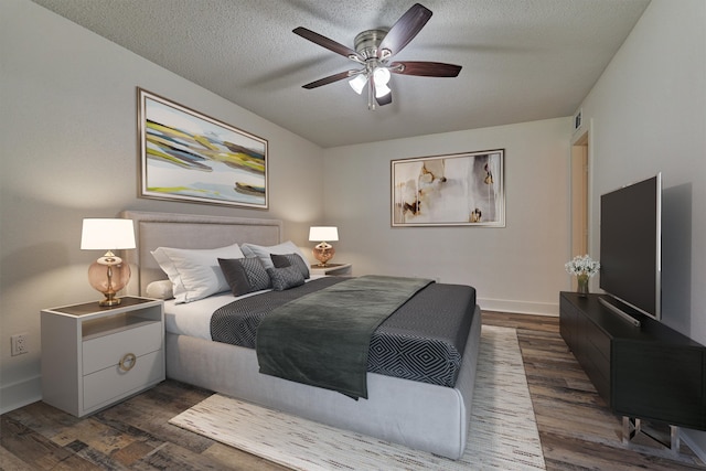 bedroom with a textured ceiling, dark hardwood / wood-style floors, and ceiling fan