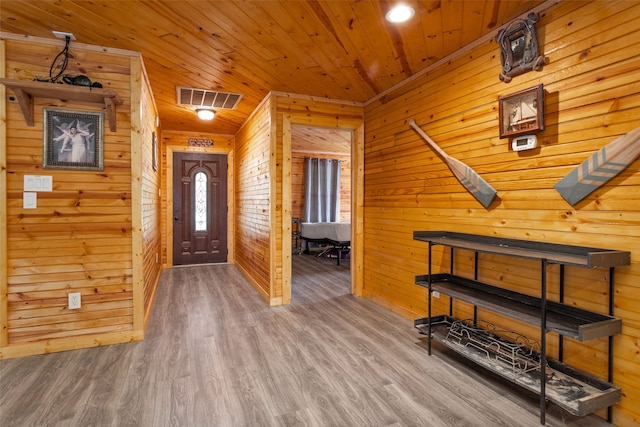 foyer entrance featuring hardwood / wood-style floors, wooden walls, and wood ceiling