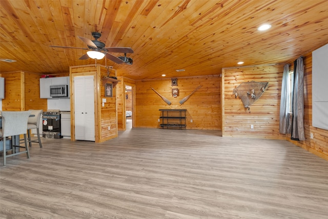 living room featuring wood ceiling, wood walls, ceiling fan, and light hardwood / wood-style floors