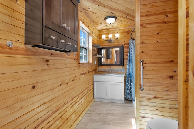 hall featuring wooden ceiling, sink, and wooden walls