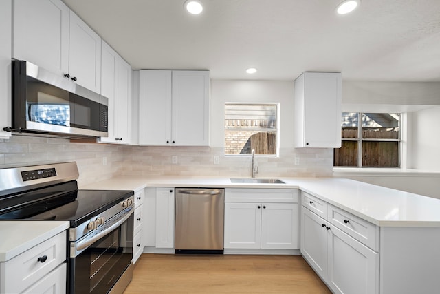 kitchen featuring white cabinets, a wealth of natural light, sink, and appliances with stainless steel finishes