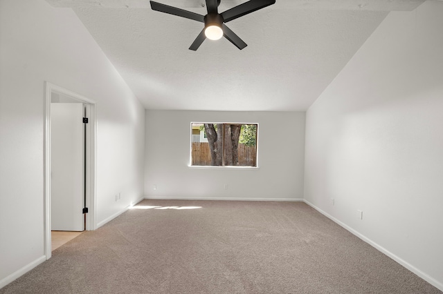 spare room featuring a textured ceiling, ceiling fan, lofted ceiling, and light carpet