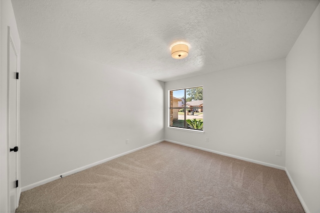 carpeted empty room featuring a textured ceiling