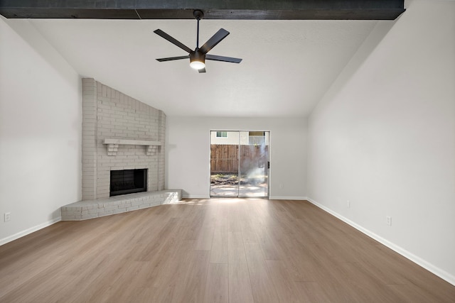 unfurnished living room with vaulted ceiling with beams, ceiling fan, hardwood / wood-style floors, and a brick fireplace