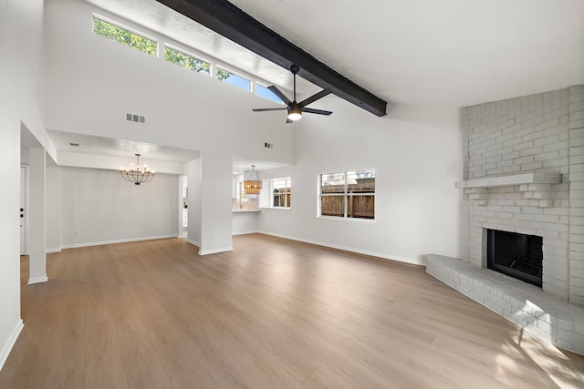 unfurnished living room with beamed ceiling, light hardwood / wood-style flooring, and a wealth of natural light