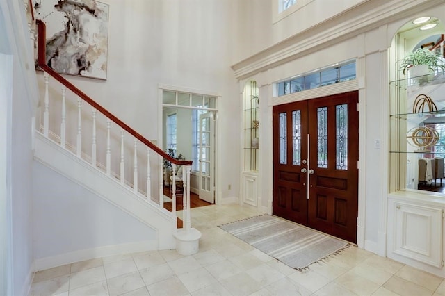 tiled entryway featuring a towering ceiling