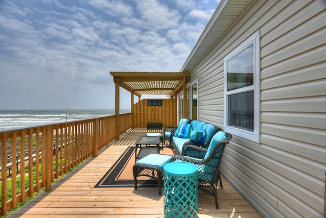 wooden terrace featuring a view of the beach, an outdoor hangout area, and a water view